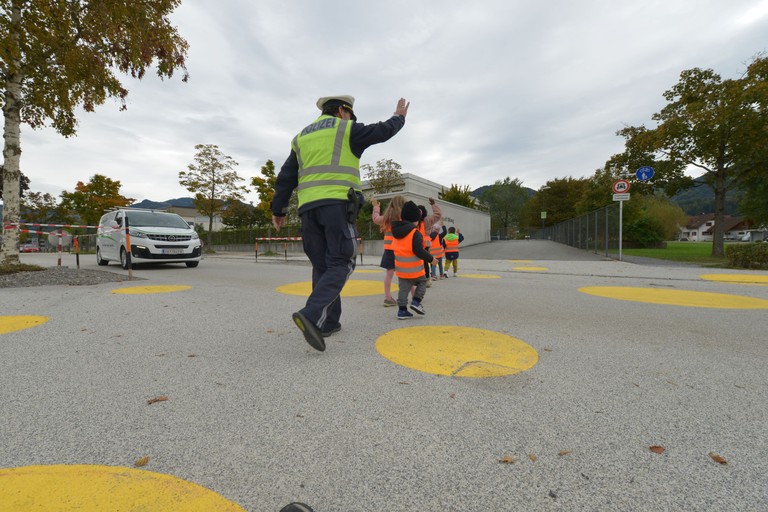 Gemeindepolizist Roland Martin mit den Kindern des Kindergartens Bifang beim Üben des Überquerens der Fahrbahn © MG Rankweil/Bernd Oswald